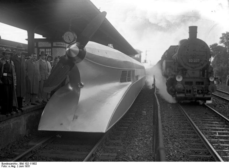 Propeller-driven railcar beside passenger platform